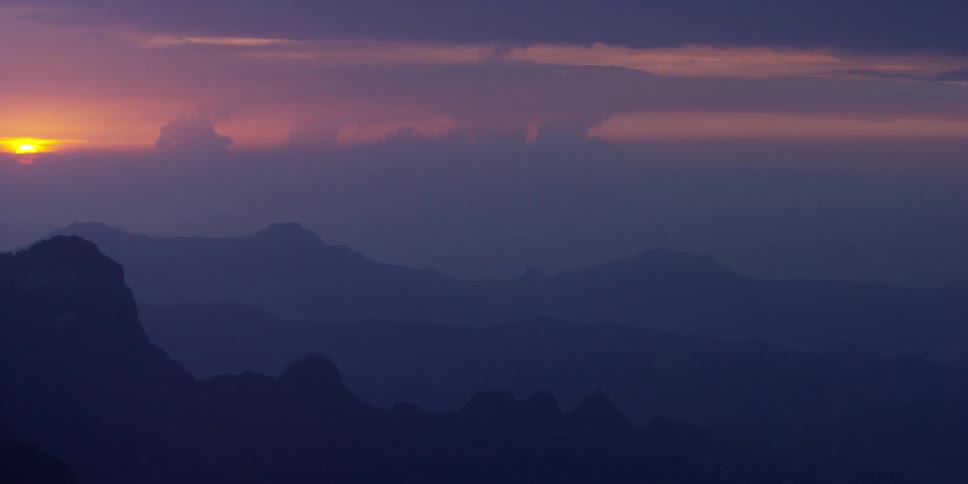 View of a foggy mountain range at sunset