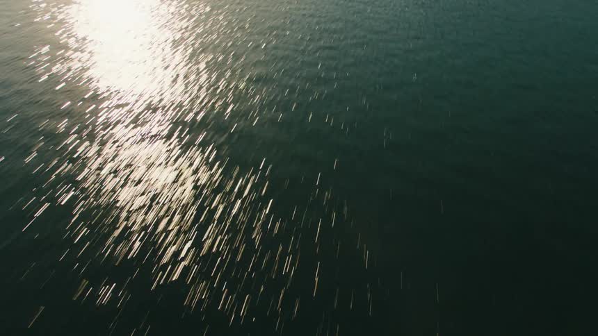 Light reflects brightly off dark blue green water