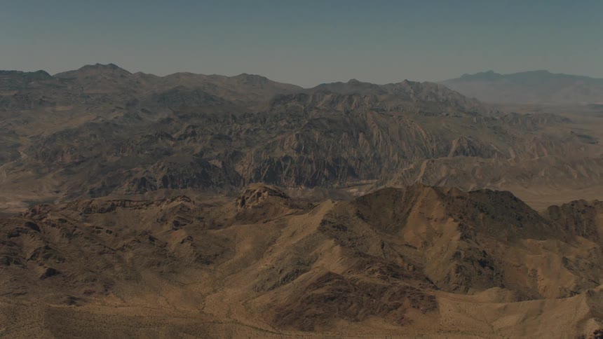 Several barren mountains are shown on a sunny day