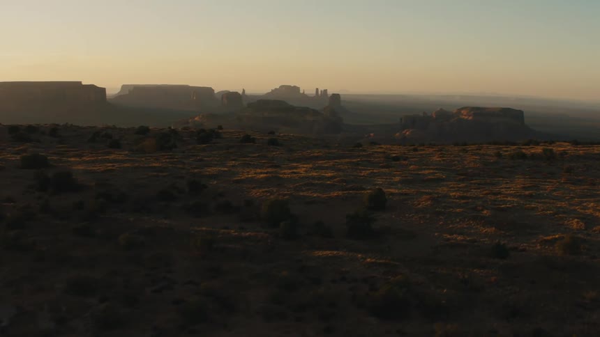 A desert with plateaus and cliffs with the sky and clouds in the background