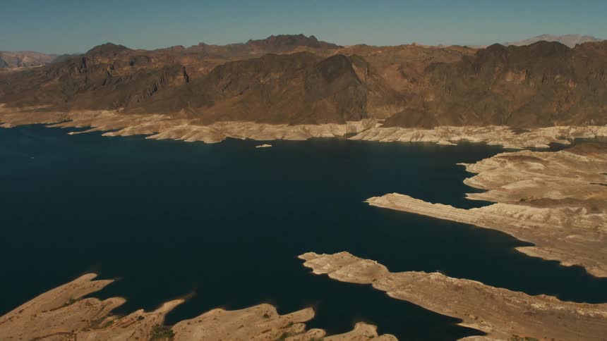 A deep blue lake sits at the base of a canyon
