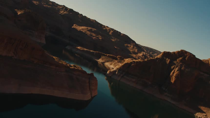 Aerial view of the placid waters of a river at the bottom of a canyon in the badlands mesas