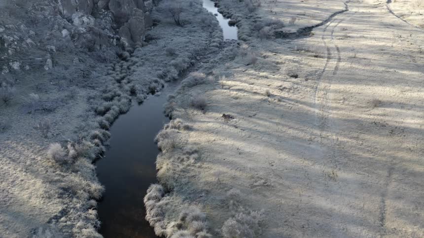 A river next to a cliff with trees in the background