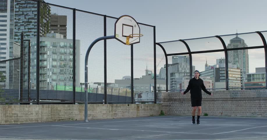 A man is jumping rope on the basketball court