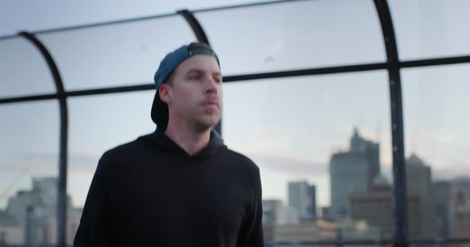 A man jump roping on a the roof of a building in a city during the day