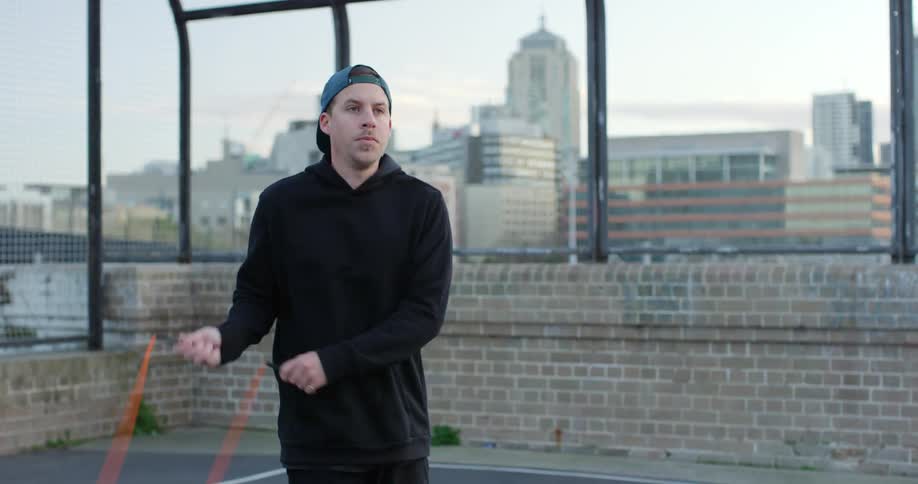 A young man jumps rope on a roof top