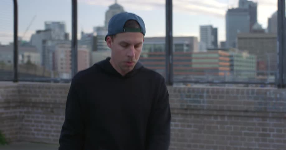 A man jumps rope on a roof top balcony with the city scenery in the background