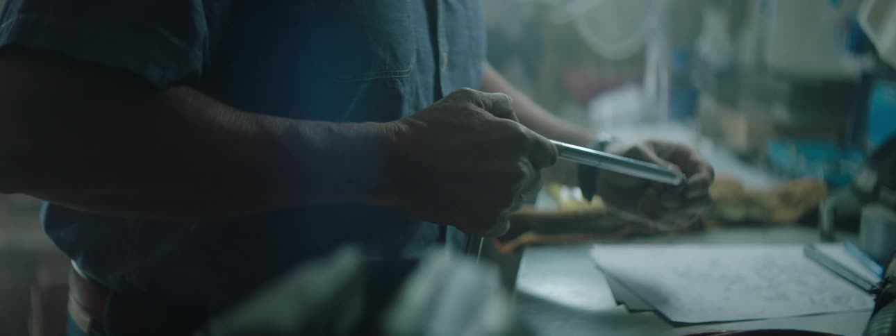 Man assembles tool at workbench in workshop