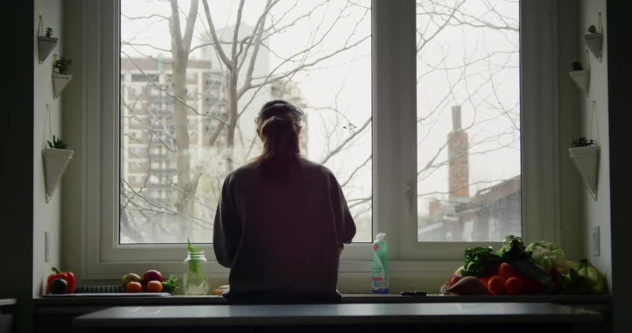 Woman rinsing off fresh produce at the kitchen sink