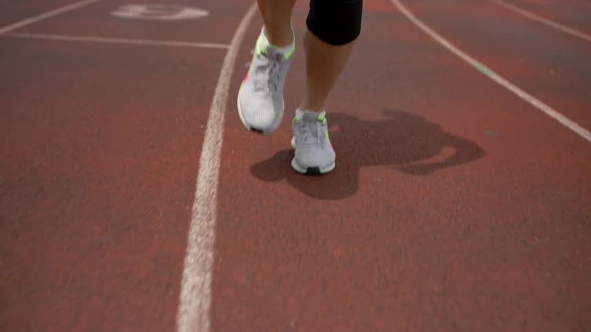 A man runs on a track as others walk around