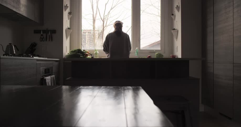 A woman is washing dishes in a kitchen