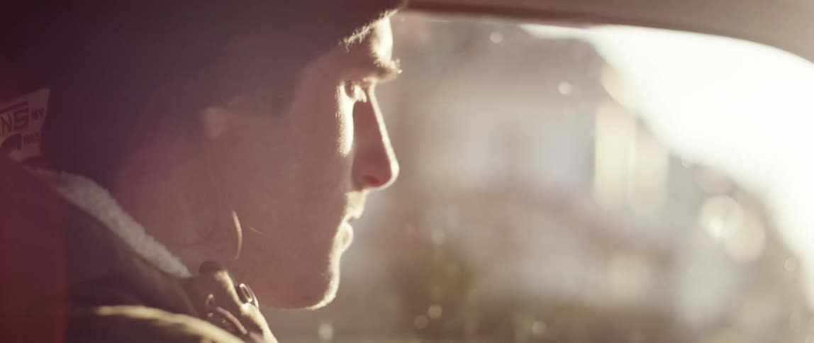 Side view of a man driving car while the sun shines bright