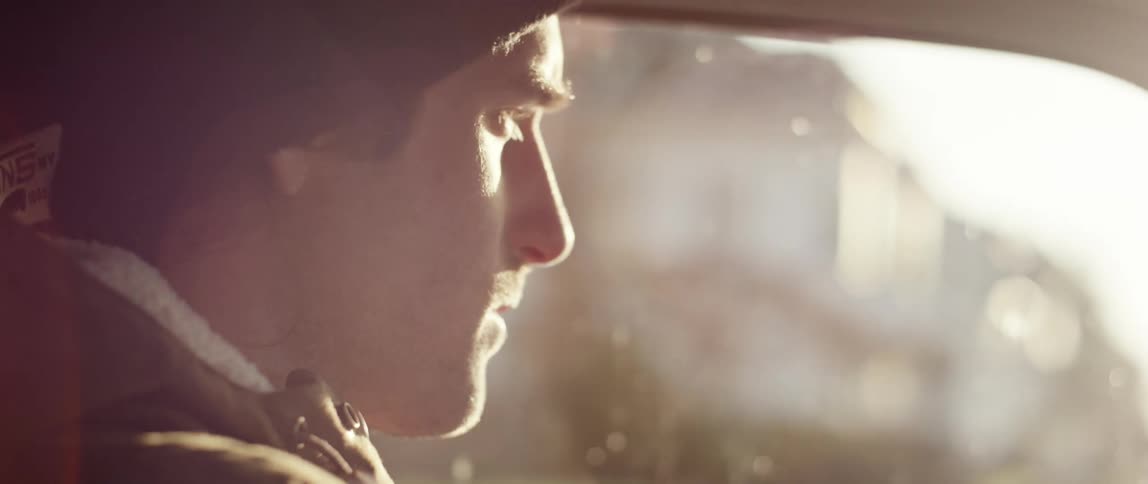 A man drives through a small town and looks out the window