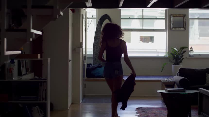 Woman wearing mini shorts goes downstairs to the living room