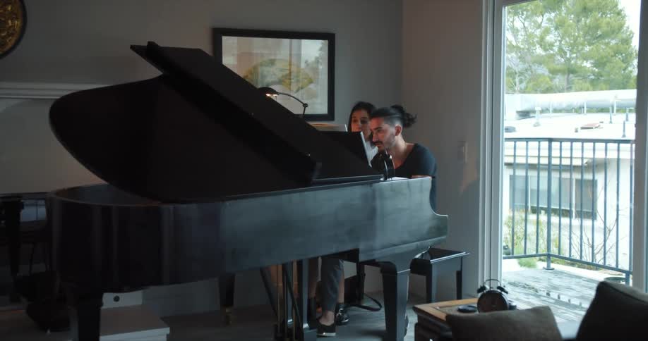 Couple sitting in front of a grand piano in the living room
