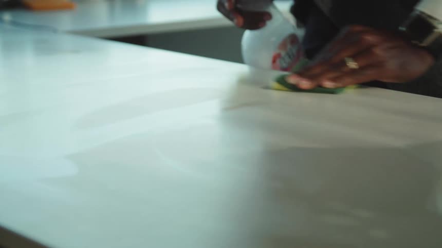 A man is washing his counter with a sponge