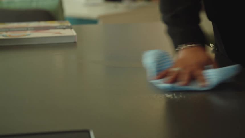 A person is cleaning the counter with a rag