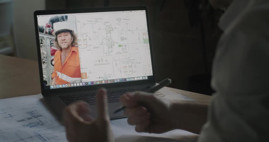 Engineer talks to a construction worker on a video call in a laptop