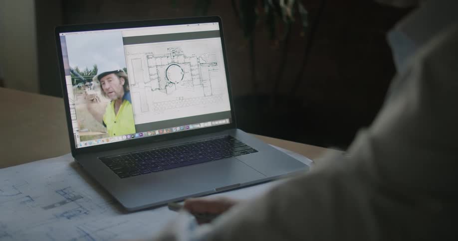 A man talks with a worker on the laptop