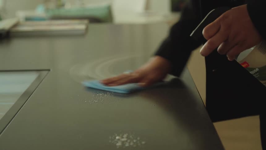 Wiping down desk with sanitizer at the office