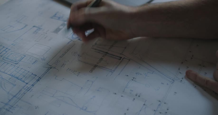 Man draws building plans on a blueprint in the office