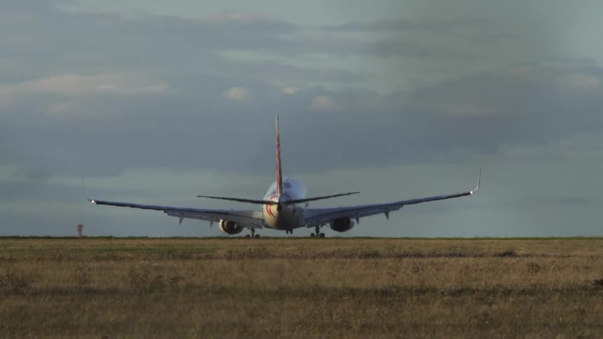 A large airplane landing at a landing strip during the day