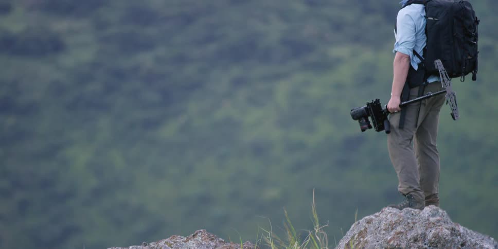 A photographer standing on top of a boulder