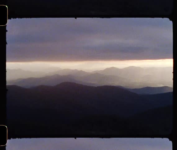 Fog covers the sky over rolling hills