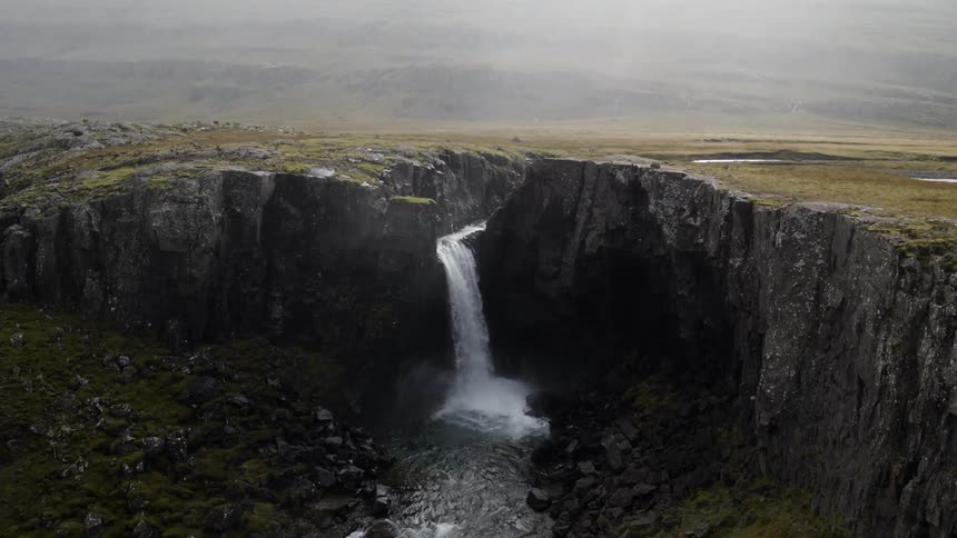 River flows over escarpment as waterfall on overcast day