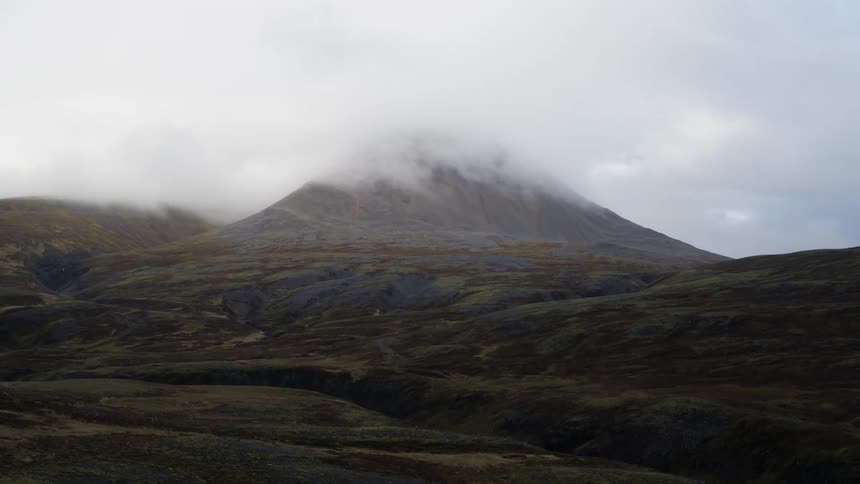 The clouds cover the top of the mountain