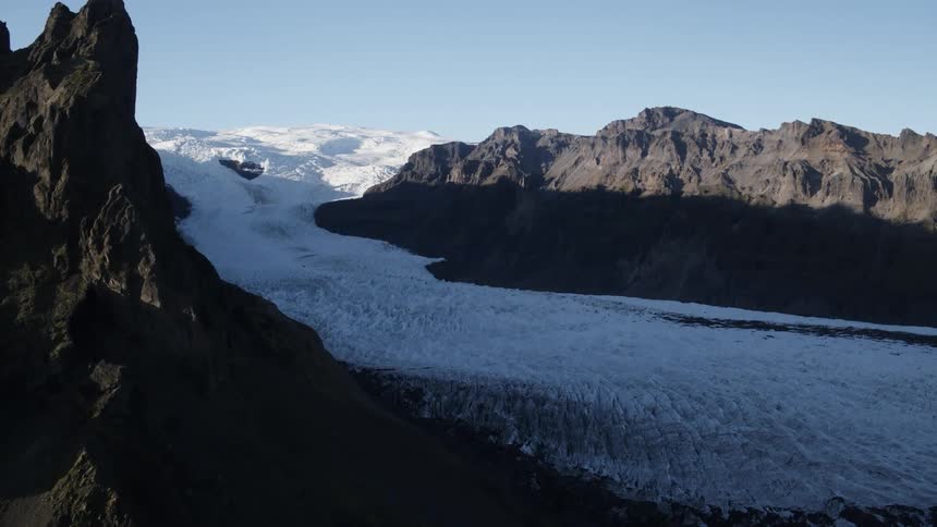 Ice and snow between mountain ridges on a bright blue sky day