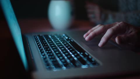 A persons hand and fingers scroll and tap on a laptop trackpad
