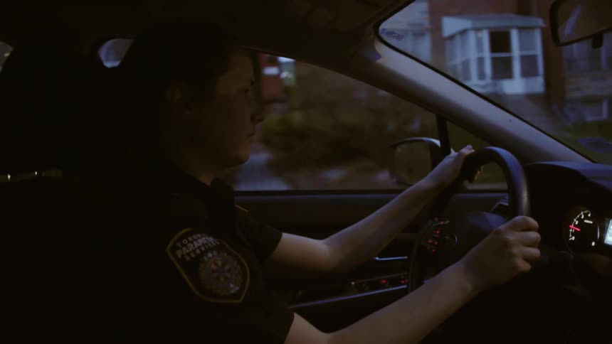 Female police officer driver car through residential neighborhood