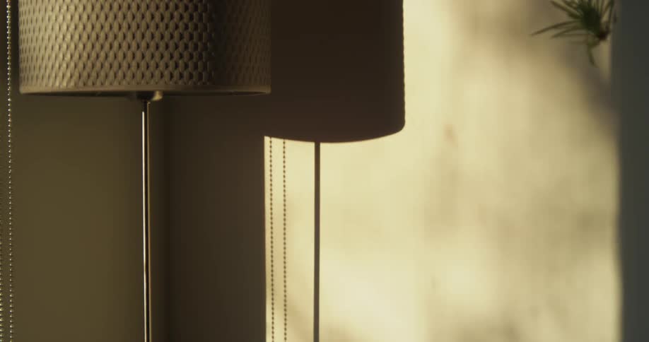Sunlight shining into a room onto a lamp causing it to cast a shadow onto a way
