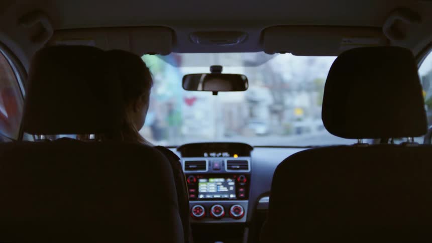 A woman driving down city streets