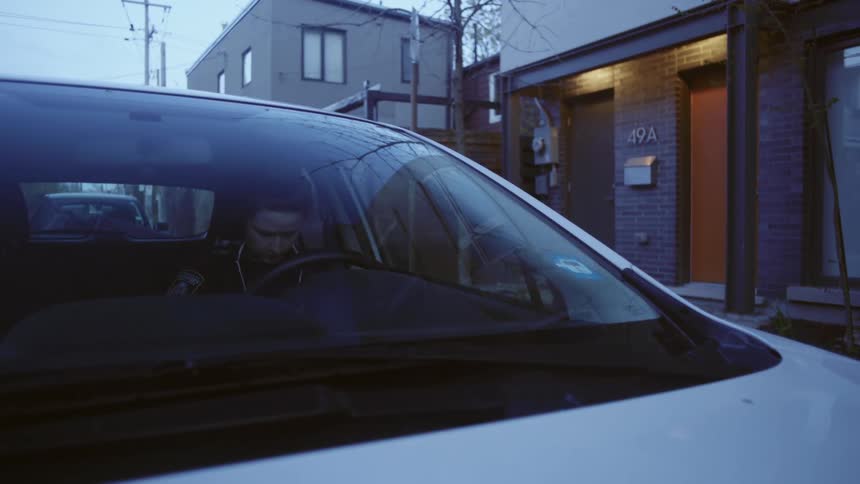 A female firefighter parks her car in front of her apartment and enters