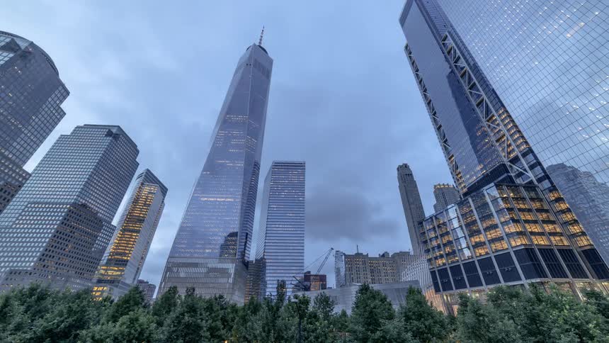 Lights glow in city skyscrapers and clouds pass overhead