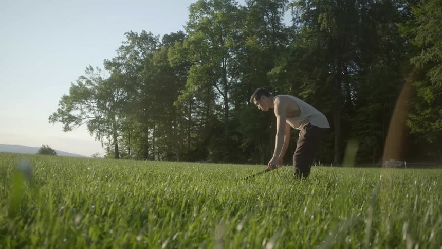 A young man lies a blanket down in the grass