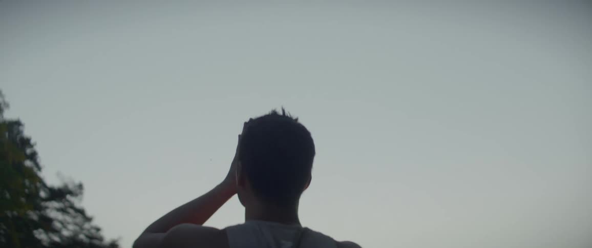 A man raises his arms and brings his hands together as he stretches and meditates at sunrise