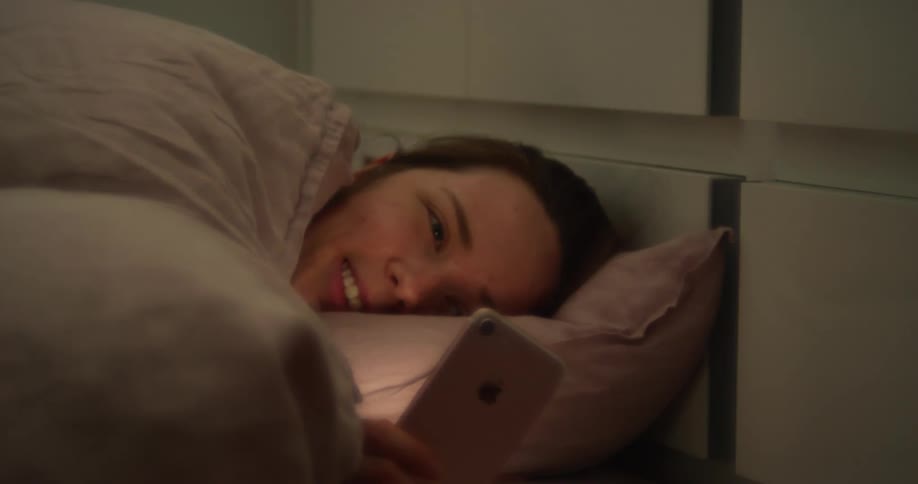 A man is laying down and using a cell phone