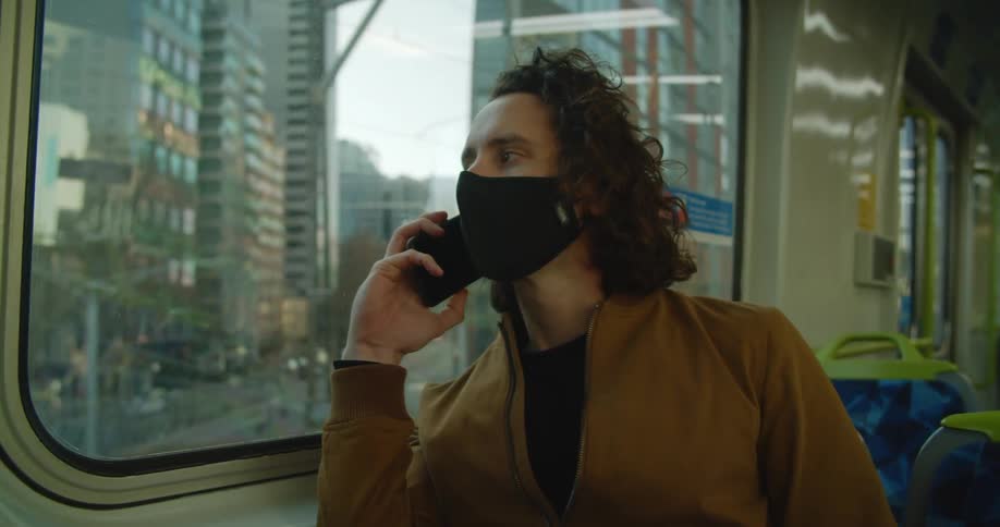 A man is riding in the train through the city
