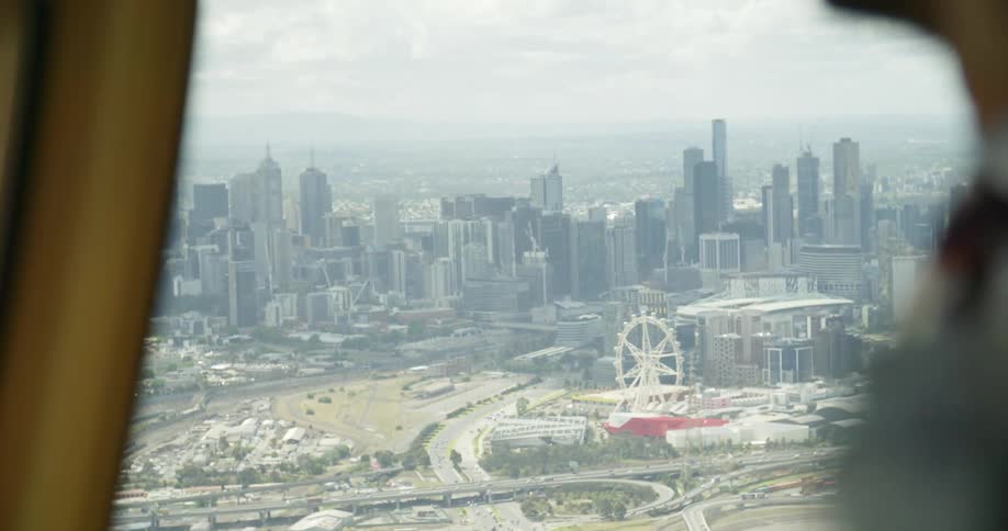 People ride in a helicopter above the city