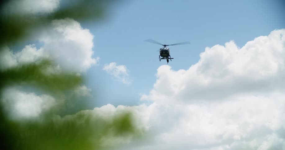 A helicopter is flying above the ground