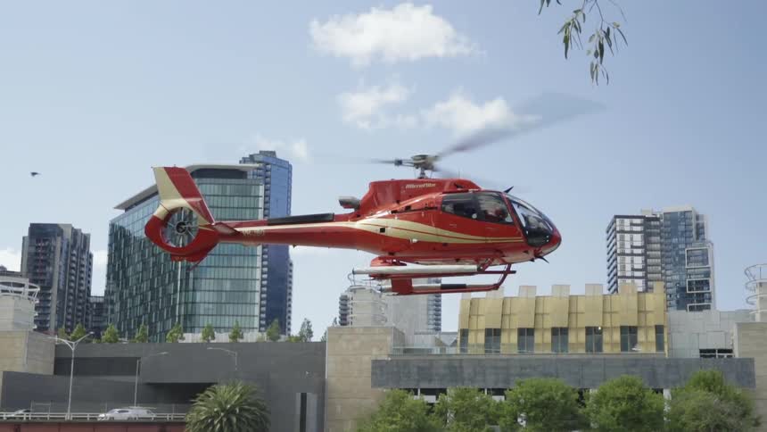 A helicopter is flying near a city skyline