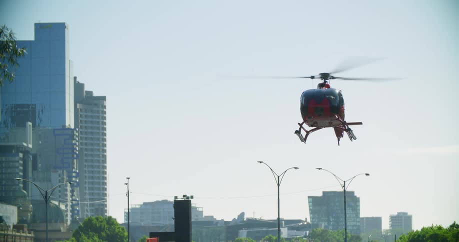 A helicopter lands on the edge of a large city