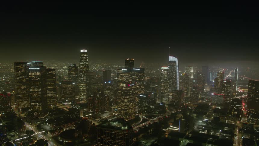 Lightning flashes on a stormy night over a city skyline glowing with lights