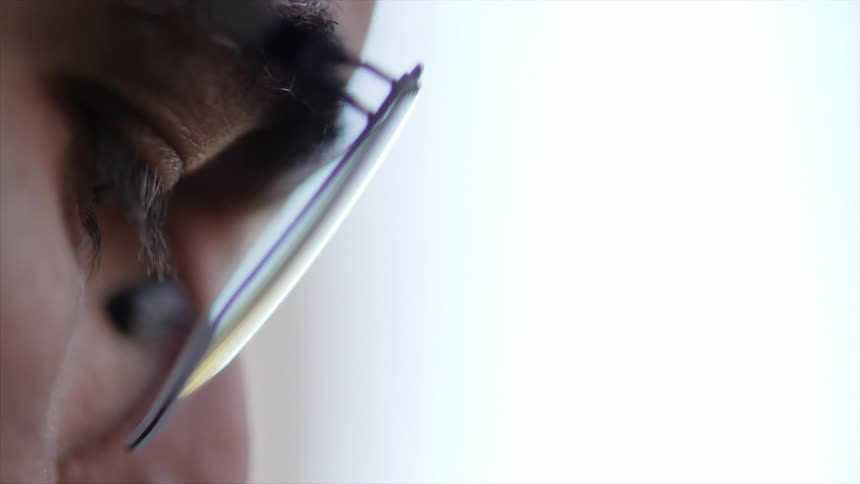 A close up view of an eye of a man with glasses