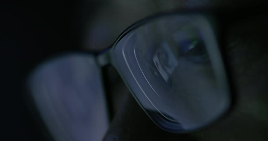 A computer monitor reflects off eyeglasses