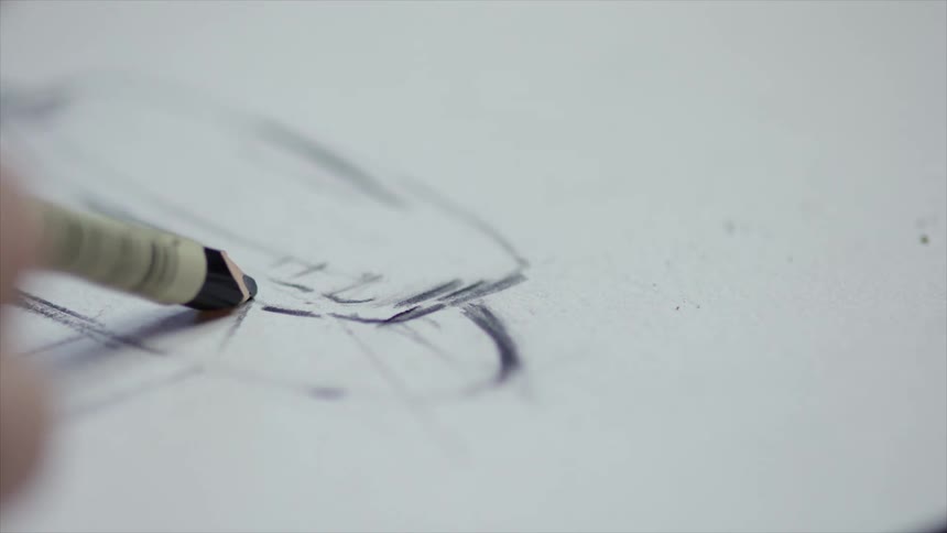 Artist draws a sketch on a white paper