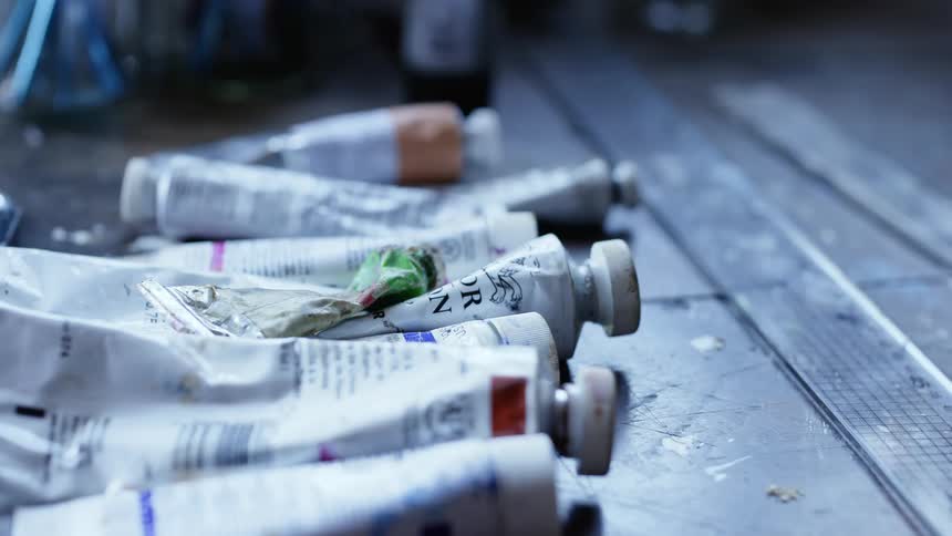Paint containers are displayed on the ground